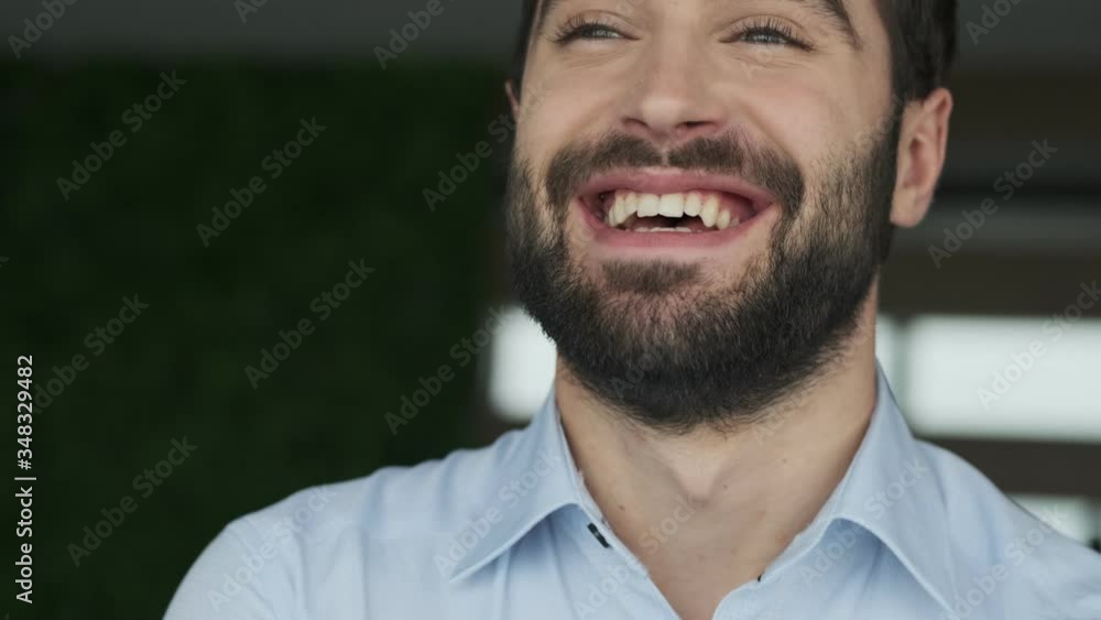 Handsome positive optimistic young business man indoors in office Handsome positive optimistic young business man indoors in office