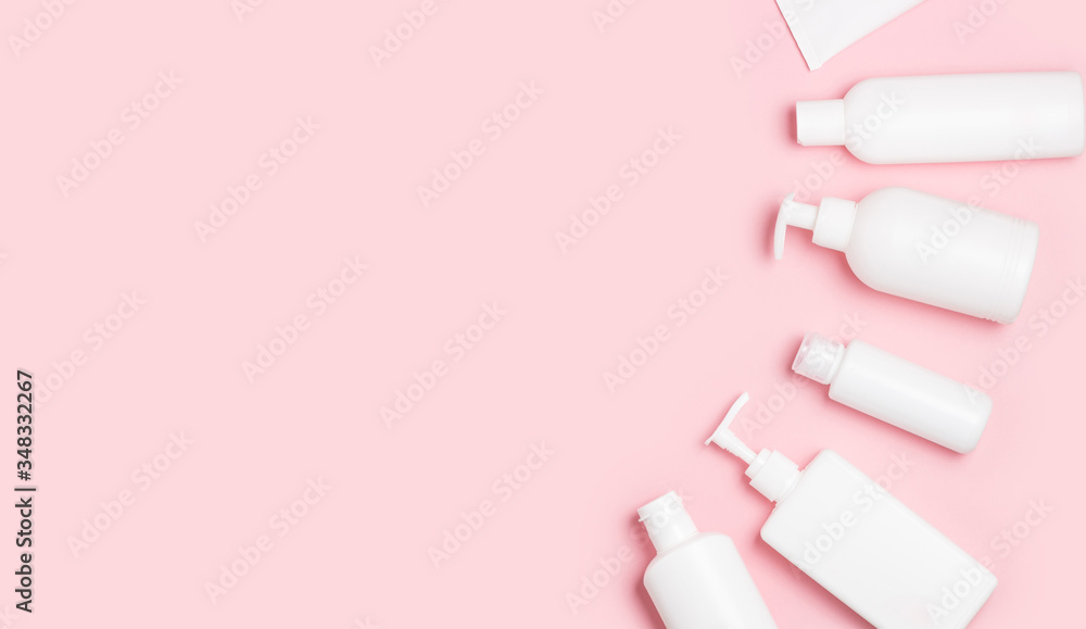 White plastic cans on a pink background. Cosmetics for skin care. Means for washing, disinfecting and washing White plastic cans on a pink background. Cosmetics for skin care. Means for washing, disinfecting and washing