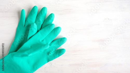 Composition with green gloves on a white wooden background