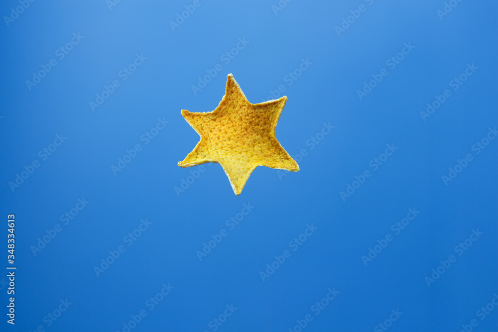 Decorative six-pointed star made of dry citrus peel on a blue background. Decorative six-pointed star made of dry citrus peel on a blue background.