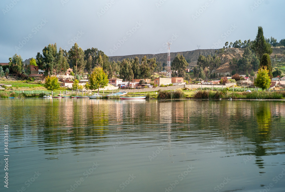 Touristic Achocalla Lagoon Surrounded by Small Recreational Boats, Green Pasture, Trees and Orange Brick Houses