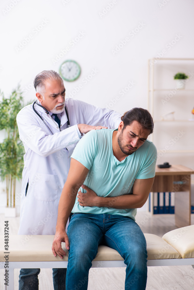 Injured young man visiting old doctor Injured young man visiting old doctor
