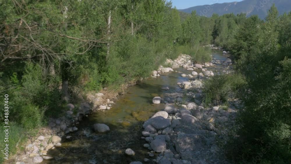AERIAL DRONE FORWARD SHOT FOLLOWING RUNNING WATER AND RIVER THROUGH FOREST WITH BIG ROUND ROCKS AERIAL DRONE FORWARD SHOT FOLLOWING RUNNING WATER AND RIVER THROUGH FOREST WITH BIG ROUND ROCKS