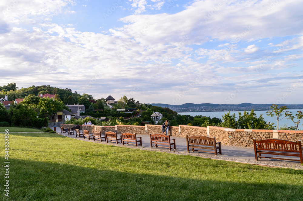 Tihany, Hungary - May 10, 2020: View from Tihany at sunset, with benches and people in the foreground