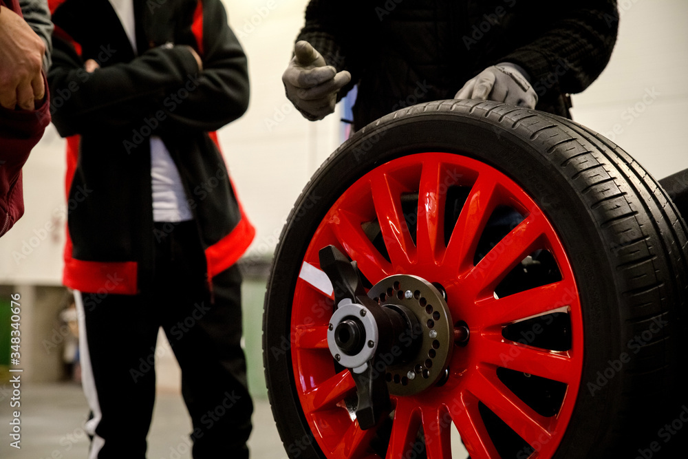 Obraz premium Presentation of a new car wheel at the car workshop