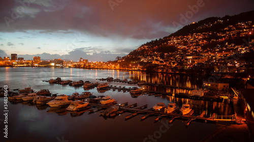 Fototapeta Naklejka Na Ścianę i Meble -  A sunset in the sea port of Bergen Norway lights on.