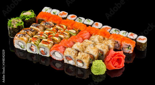 Assorted Sushi maki set with ginger and wasabi isolated on black background with reflection