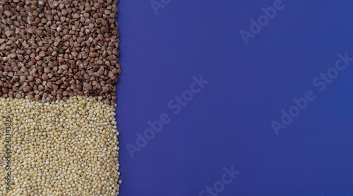 Purple background with brown fried buchwheat and yellow millet, donation concept during quarantine, cereal concept, copy space,