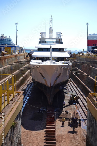 Fototapeta Photo of ship repairs of yacht in hull in shipyard floating dry dock