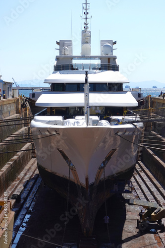 Photo of ship repairs of yacht in hull in shipyard floating dry dock