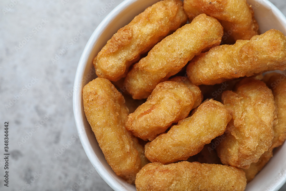 Bucket with tasty chicken nuggets on grey table, top view Bucket with tasty chicken nuggets on grey table, top view