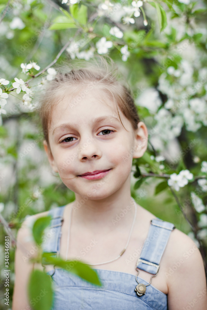 Beautiful little girl near flowering trees Beautiful little girl near flowering trees