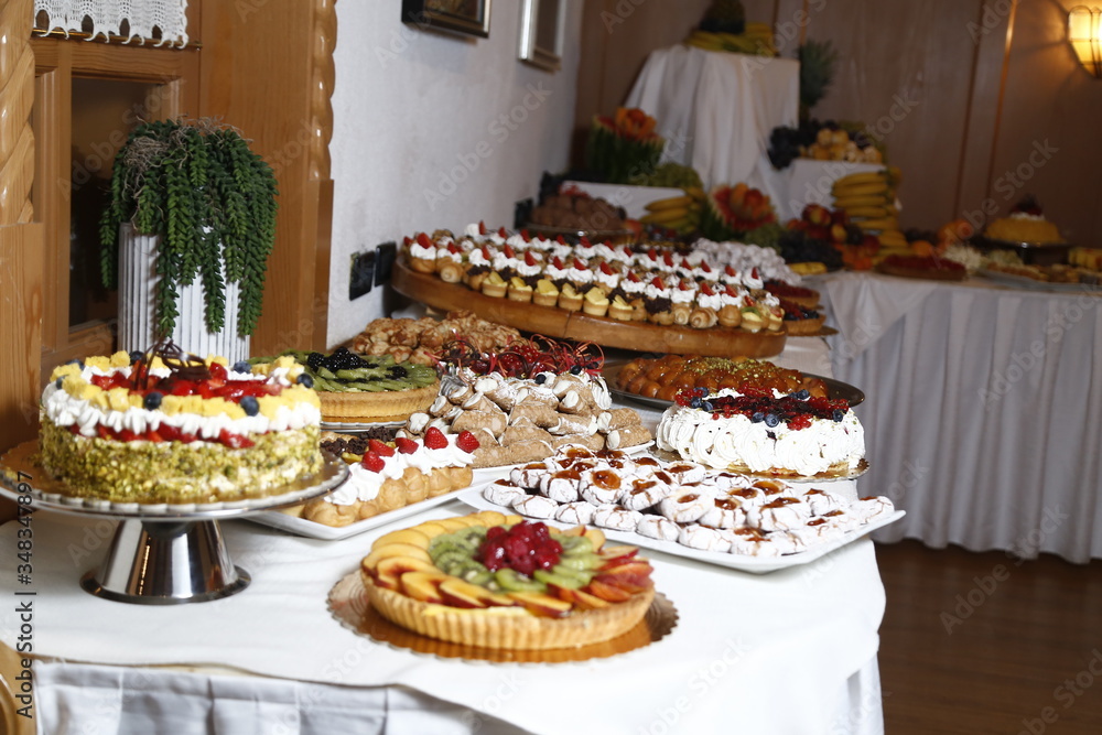buffet with sweets. fruits and other sweets on dessert table. Rows of tasty looking desserts in beautiful arrangements. Sweets on banquet table - picture taken during catering event buffet with sweets. fruits and other sweets on dessert table. Rows of tasty looking desserts in beautiful arrangements. Sweets on banquet table - picture taken during catering event