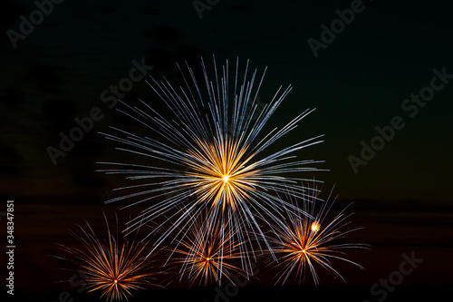 Festive fireworks in the sky for a holiday. Bright multi-colored salute on a black background. Place for text.