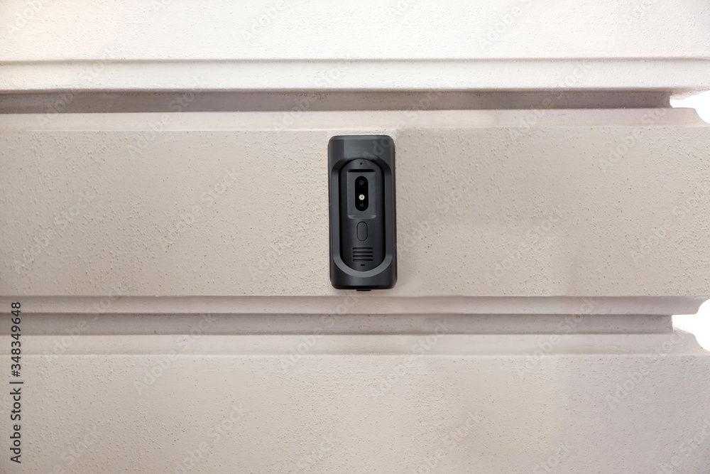 intercom with a doorbell and video link, closeup of a security device on a wall with copy space on outdoors exterior nobody.