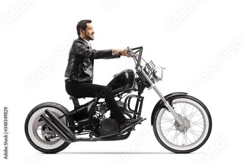 Young man in leather jacket riding a chopper motorbike