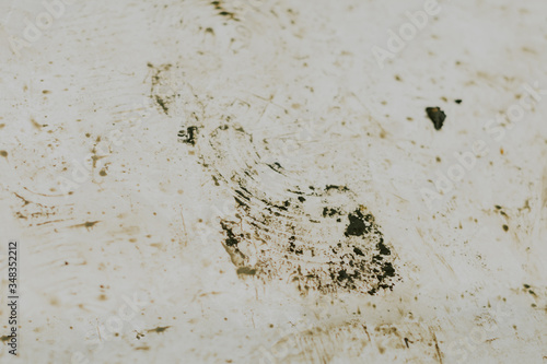 Black wet footprints over dirty tiles 