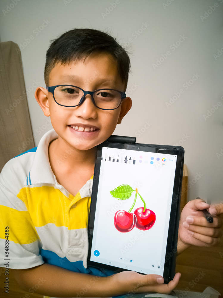 Bangi, Malaysia Feb 3, 2020 A young boy wearing glasses is proudly showing his digital art