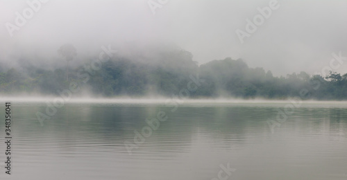 Fog in the middle of a green lake