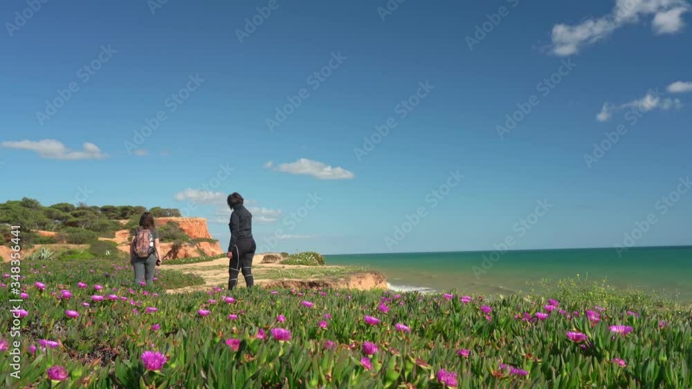 Sports successful women tourists strolling along a cliff on the ocean. Mom with a daughter. Sports successful women tourists strolling along a cliff on the ocean. Mom with a daughter.