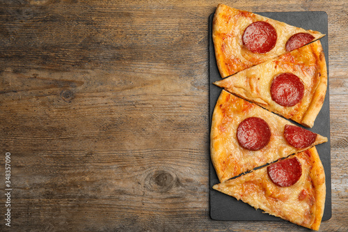 Tasty pepperoni pizza on wooden table, top view. Space for text