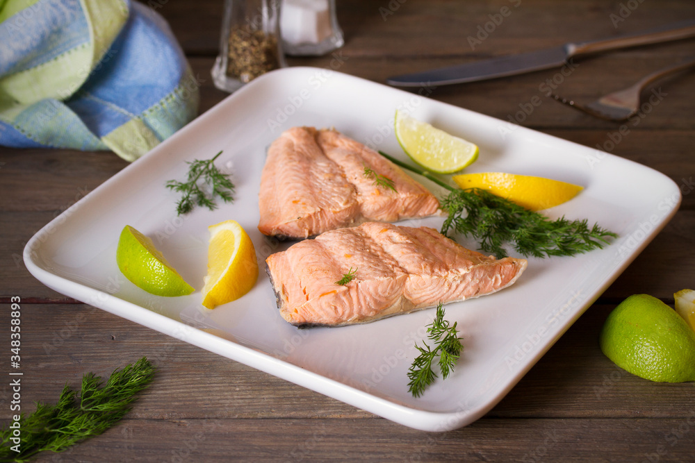 Steam cooked salmon with lemon and dill on white plate. Healthy diet detox food concept Steam cooked salmon with lemon and dill on white plate. Healthy diet detox food concept