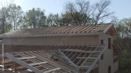 Wallpaper Mural Flying backwards above the planks of the roof of a new frame house. Aerial zooming out view of a nailer gun left on the roof by builders Torontodigital.ca