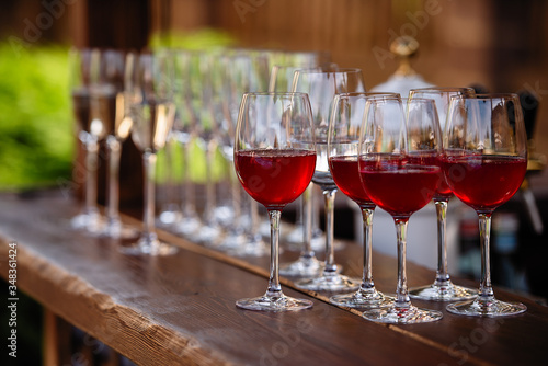 glasses with red wine, fruit drinks are poured into glasses, drinks are poured into glasses, clear glass is on the table
