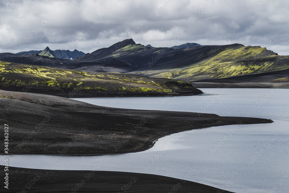 View of Lambavatn lake in Lakagigar volcanic desert in Iceland Skaftafell national park. Landscape with black sand ash and green moss.