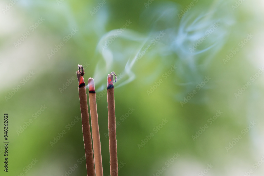 Incense stick and smoke from incense burning. Beautiful smoke. Blurred background and design Incense stick and smoke from incense burning. Beautiful smoke. Blurred background and design