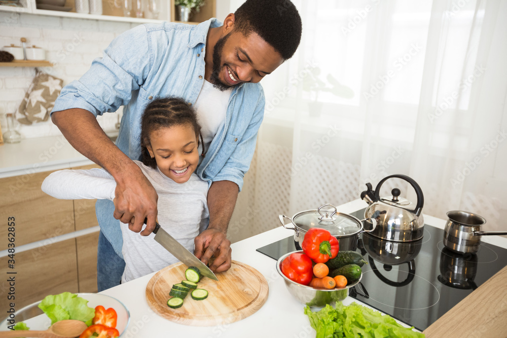 Dad teaching little daughter how to cut veggies Dad teaching little daughter how to cut veggies