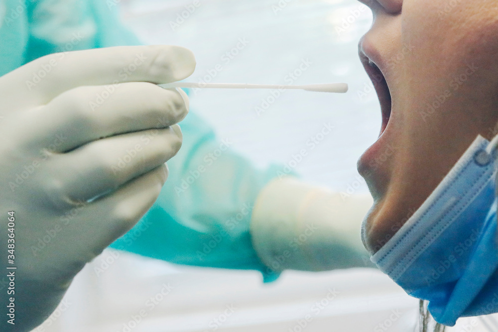 Medical in protective clothing takes COVID-19 swab test tube from mouth at Covid-19 test center during corona virus epidemic. PCR DNA testing protocol process. Medical in protective clothing takes COVID-19 swab test tube from mouth at Covid-19 test center during corona virus epidemic. PCR DNA testing protocol process.