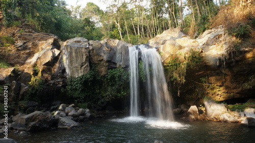 Waterfall in forest landscape long exposure flowing through trees and over rocks