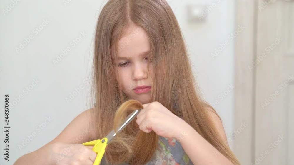 little girl cutting hair to herself with scissors little girl cutting hair to herself with scissors