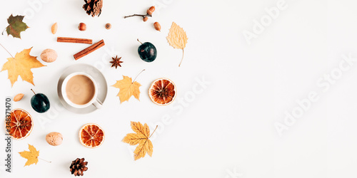 Autumn creative composition. Coffee with milk, shawl, cinnamon sticks, dried orange, acorn, chestnut, anise star, autumn leaves on white background. Fall concept. Flat lay, top view, copy space