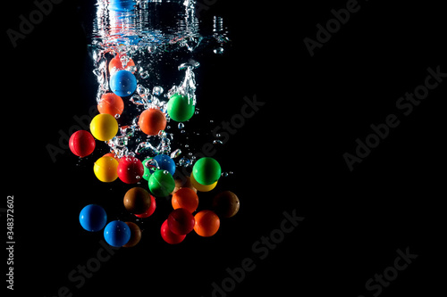 colored balls falling into the water and splashing