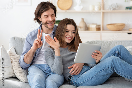 Man and woman having video conference  using tablet at home