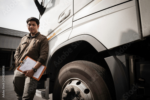 portrait of Asian a truck driver holding clipboard inspecting safety a truck, vehicle maintenance checklist a truck, road freight industry logistics.