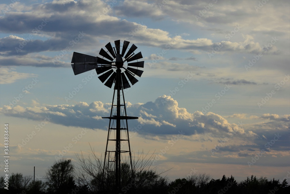 Kansas Country Windmill with clouds at Sunset out in the country. Kansas Country Windmill with clouds at Sunset out in the country.