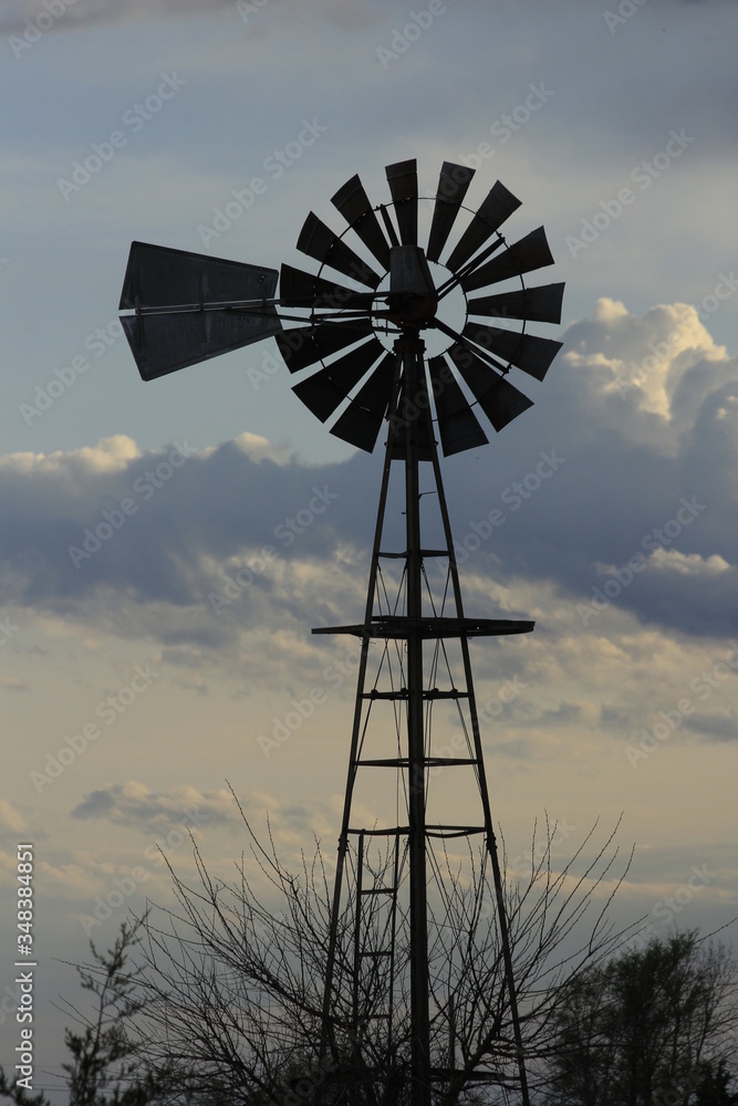 Kansas Country Windmill with clouds at Sunset out in the country. Kansas Country Windmill with clouds at Sunset out in the country.
