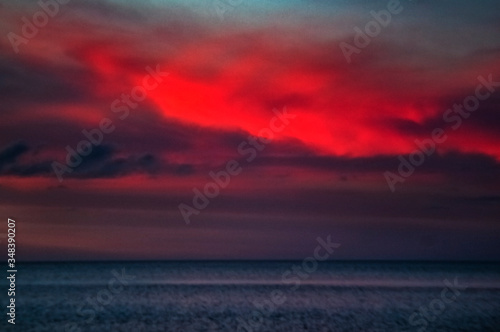 sunset over the sea, sky, ocean, clouds, water, beach, summer, dramatic, red, beautiful, coast, blue, intense, seascape © Renee