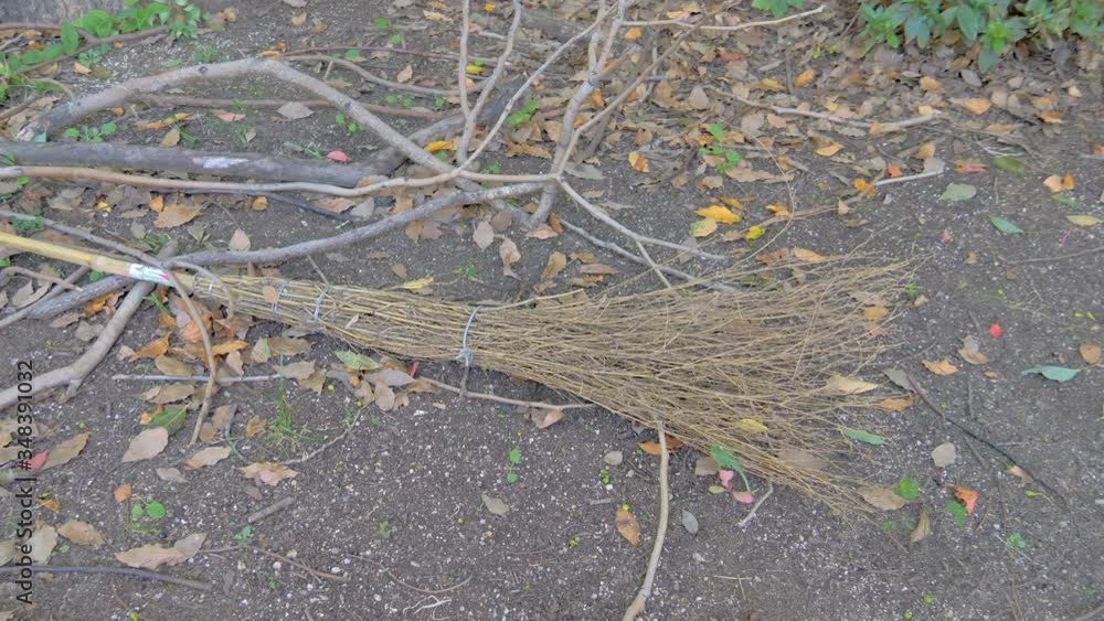 An old broom on the ground near the garden An old broom on the ground near the garden