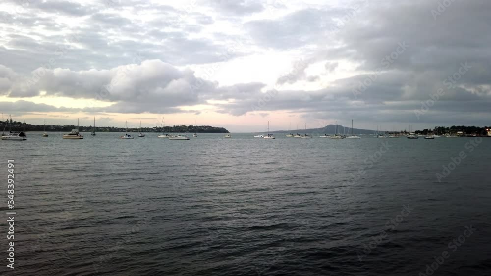 Serene view of a harbor in New Zealand, tranquil ocean surface, boats on horizon Serene view of a harbor in New Zealand, tranquil ocean surface, boats on horizon