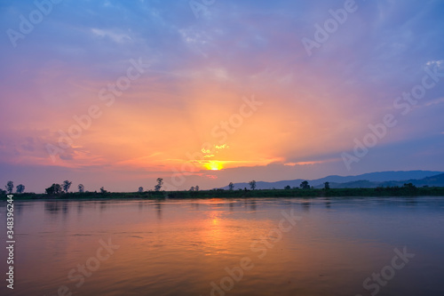 The setting sun is blue and orange.Beautiful sky in the evening by the river © gexphos