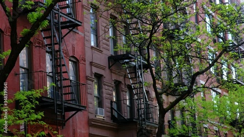 Wallpaper Mural Red residential apartment buildings with fire escapes and trees on a beautiful spring day. Torontodigital.ca