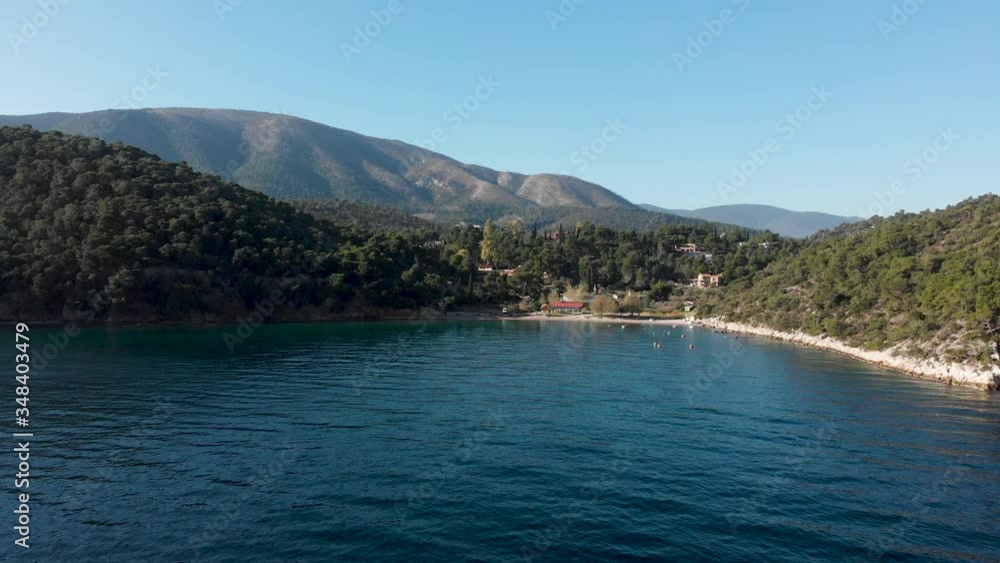 A small, beautiful beach by the green mountain rocky shoreline of Greece - aerial