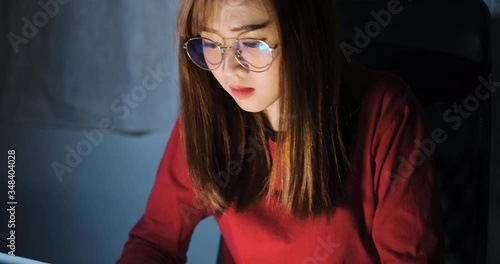Asian woman working late at night with laptop computer home office looking screen monitor unhappy work hard, Freelancer stay home business quaratine sleepless crisis coronavirus stay home dark room. photo