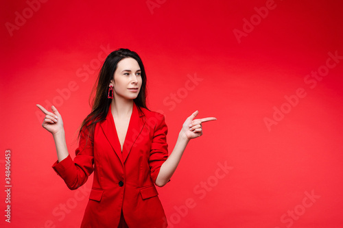 Happy cauasian female with long dark straight hair in red office suit rejoices photo