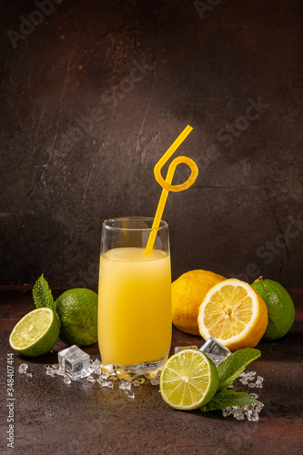 Delicious cold refreshing banana smoothie drink in cocktail glass with lime and lemon photo