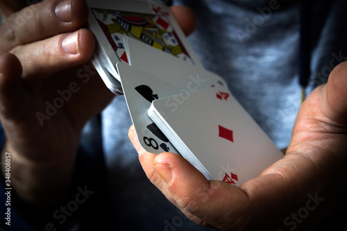 Fotografie A deck of playing cards in hand, shuffling the deck, gambling.